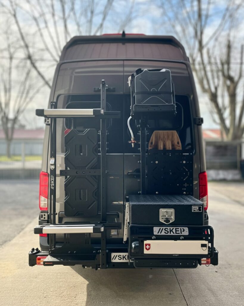 Vue de face du porte-à-faux arrière SKEP avec jerricans, malle de rangement et plaque d'immatriculation suisse