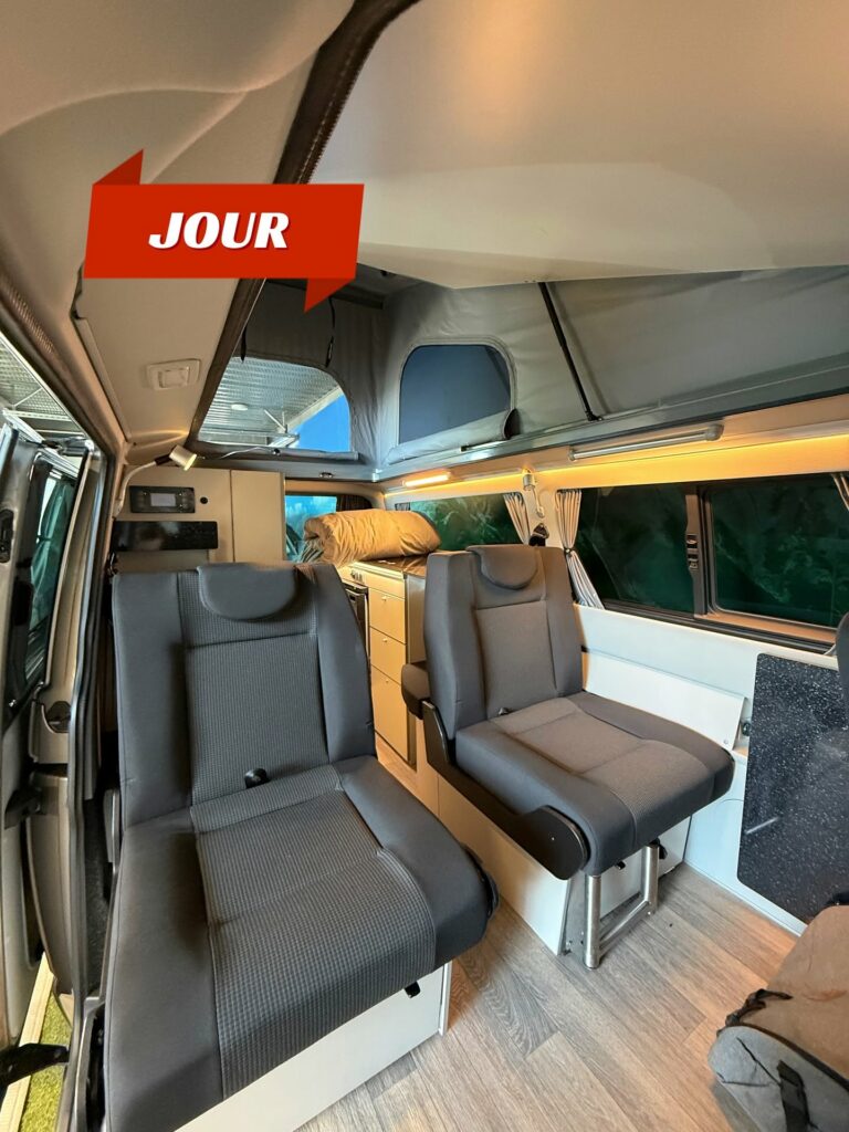 Intérieur d'un van aménagé REIMO en mode jour, sièges pivotants et espace de vie modulable, Eco Campers